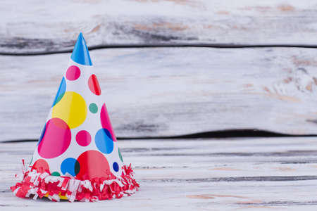 Holiday hat on wooden background. Paper Birthday hat on rustic wooden background with copy space....