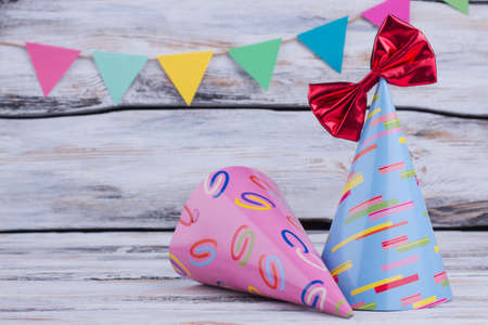 Carnival or Birthday party background. Colorful party hats and paper flags on gray wooden background. Festivity concept.の写真素材