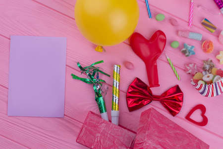 Birthday party accessories and blank paper card. Balloons, blowers, candies and other decorations for kids Birthday party.の写真素材