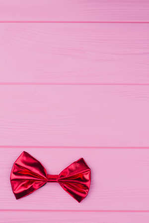 Red bow-tie on color background. Holiday background with copy space for greeting.の写真素材