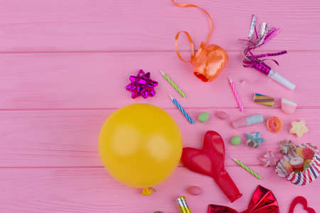 Carnival or Birthday party items with copy space. Colorful Birthday party background with balloons, blowers, candles, candies and other accessories.の写真素材