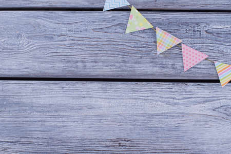 Bunting flags on wooden background. Paper party flags on wooden boards with text space. Holiday party decoration.の写真素材