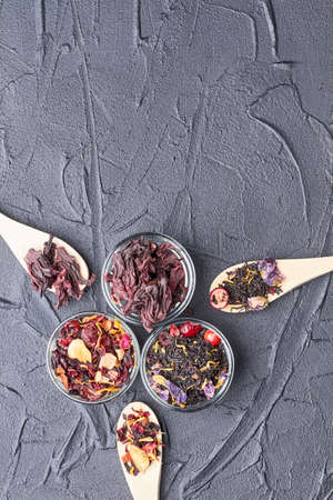 Hibiscus tea, green tea and fruity tea. Set of different herbal and fruit dry teas on stone concrete background. Top view with copy space.の写真素材