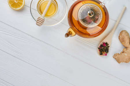Teapot with honey and lemon on wooden table. Space for text. Health benefits of ginger.の写真素材