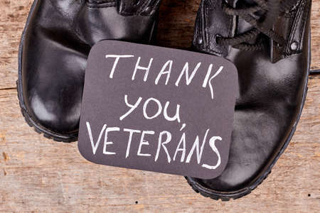 Thank you veterans concept. Close up black shiny boots.