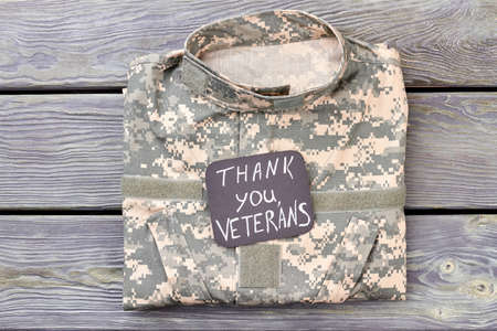Veterans camo jacket, top view. Thank you veterans, wooden background.