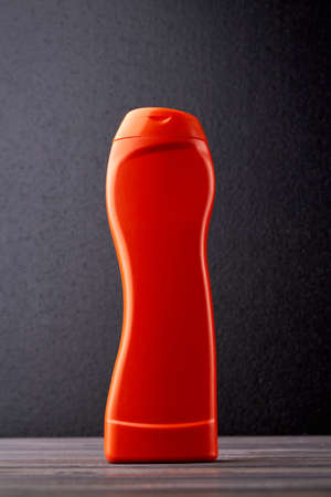 Orange plastic bottle with detergent. Bottle with cleaning chemistry. Housekeeping and household concept.の写真素材