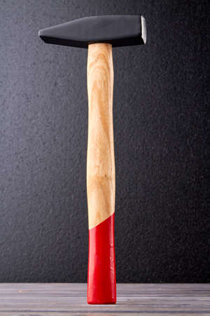 Metal hammer with red handle. Construction tool on dark background, vertical image.の写真素材