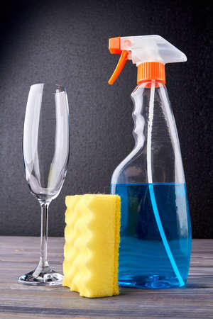 Cleaning spray, wine glass and kitchen sponge. House cleaning supplies. Household chores concept.の写真素材
