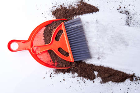 Dustpan and dust brush on the dirty floor. Close up soil on the floor. Cleaning concept.の写真素材