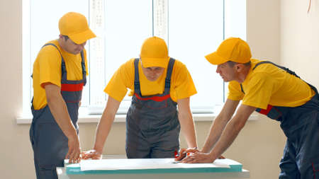 Builders working with documents on construction site. Building and home renovation.の写真素材