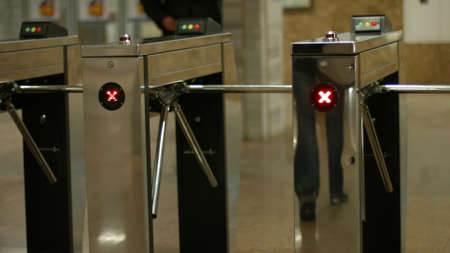 Turnstiles in the subway. People pass through the turnstiles. Check point.