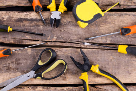 Set of construction tools on a wooden background. Frame from different instruments for repair with...