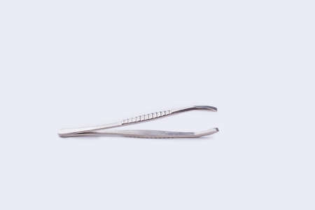 Metal eyebrow tweezers isolated on white background. Small tool for picking up objects.の写真素材