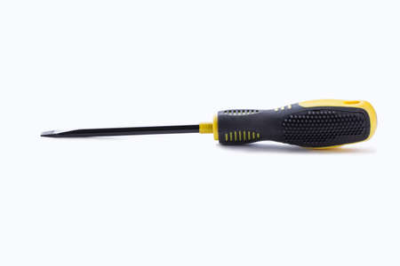 Screwdriver with black and yellow handle. Flathead screwdriver with rubber handle on white...