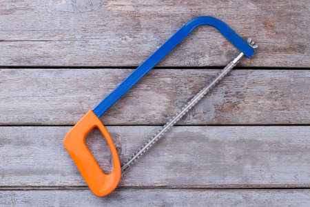 Hand saw on vintage wooden background. Saw on rustic wooden boards. Carpentry concept.の写真素材