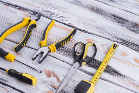 Set of tools on wooden background. Pliers, screwdrivers, scissors and measuring tape. Tools for...