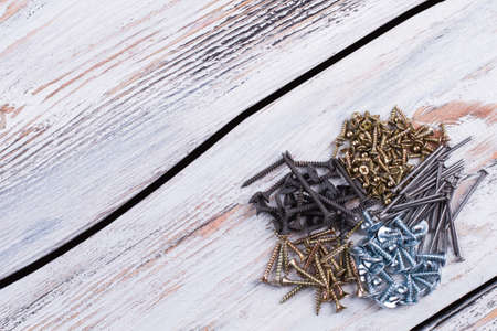 Heart from screws and copy space. Various screws forming heart shape on wooden background. Space for text.の写真素材