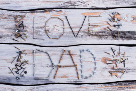 LOVE DAD inscription on wooden surface. Greeting card made of tools. Happy Fathers Day.