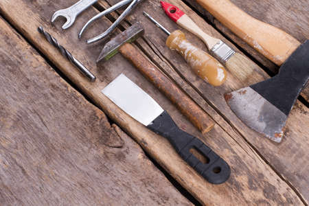 Old working tools. Different tools on vintage cracked wooden background.