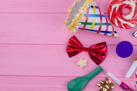 Birthday party accessories on color background. Festive Birthday background with party hat, bow-tie,...