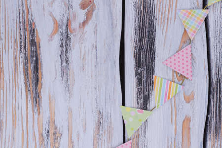 Birthday paper flags on rustic background. Decorative party flags on vintage wooden background with...