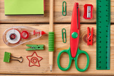 Colorful school items on wooden boards. Scissors, pencil, ruler, notebook, adhesive tape and other accessories for education.の写真素材