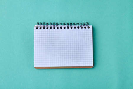 Blank paper notebook on turquoise background. Empty spiral notepad on color background.の写真素材