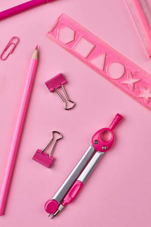 Education background with stationery supplies. Stationery items on pink background. Vertical image.