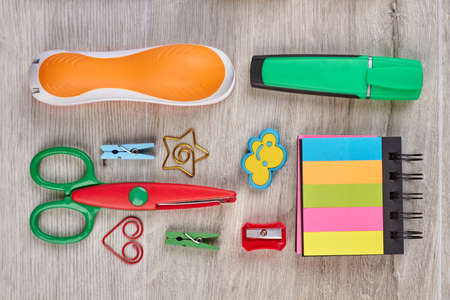 School supplies on wooden background. Planner, stapler, scissors and marker. Back to school concept.