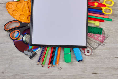 School supplies on wooden background. Colorful school accessories and blank note paper.の写真素材