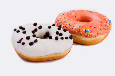 Fresh donuts with icing on white background. Pastry with colorful glaze. Concept of unhealthy food.の写真素材