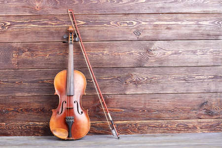 Antique violin on wooden background. Stringed musical instrument and copy space. Cello for musician.の写真素材