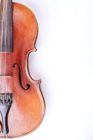 Old violin and copy space, vertical image. Vintage musical instrument of orchestra isolated on white background.の写真素材