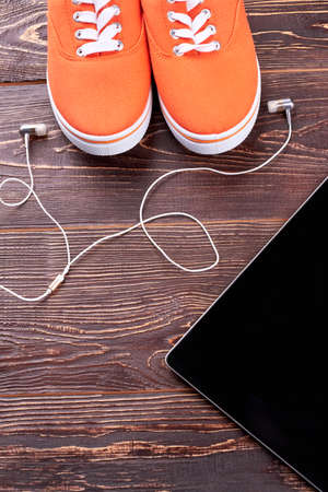 Female sneakers, earphones and pc tablet. Fitness flat lay. Sport and modern technology.の写真素材