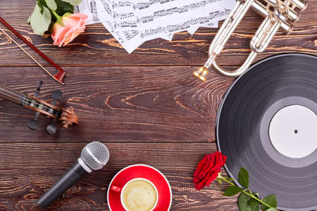 Musical instruments, roses and copy space. Trumpet, violin, vinyl record, musical notes, microphone,...