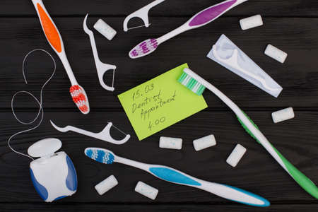 Dentist appointment message and tooth care products. Dentist appointment card, toothbrush, dental...