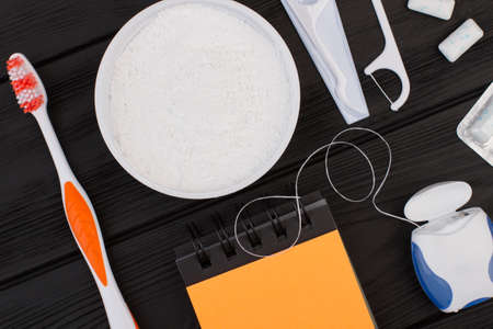 Set of cleaning products for teeth on black background. Tooth care with toothbrush, dental floss,...