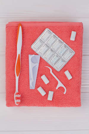 Daily oral hygiene background. Bath towel with toothbrush, dental floss toothpick and chewing gums, top view.の写真素材