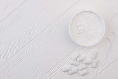 Powder for cleaning teeth and chewing gums. Container with white powder, dental toothpick and...