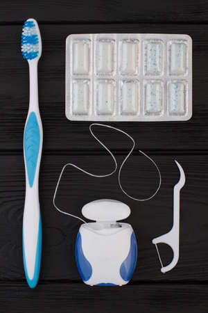 Products for dental care, top view. Toothbrush, dental floss, chewing gums and dental floss...