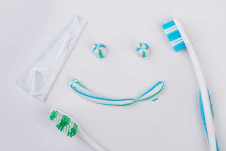 Smiling emoji face painting with toothpaste. Smile from toothpaste and toothbrush on white background. Concept of oral hygiene.の写真素材