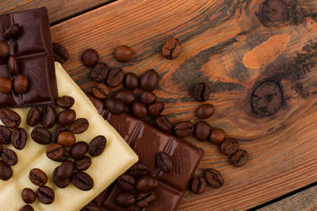 Chocolate bar with coffee beans. Coffee beans and chocolate on brown wooden background. Space for text.の写真素材