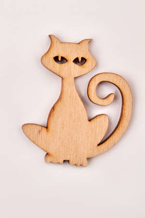Wooden silhouette of a cat, vertical image. Plywood animal cutout isolated on white background. Decorative pet cut from wood.の写真素材