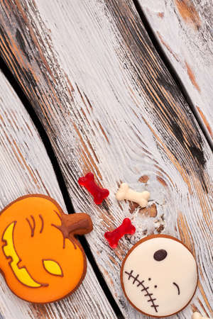 Halloween holiday background with cookies. Halloween gingerbread cookies in a shape of pumpkin and Jack Skellington. Traditional Halloween baked pastry.の写真素材