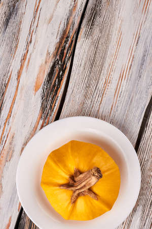 Pumpkin stem on wooden background, top view. Plate with pumpkin, copy space. Abstract pumpkin background.の写真素材