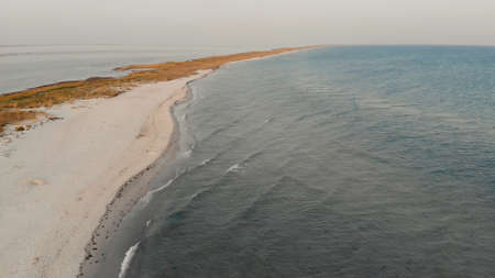 Amazing seascape with beach and sea with blue water. View of the sunset on the waving sea. Best place for summer vacation.の写真素材