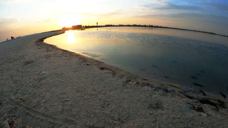 Scenic view of beautiful sunset above the sea. Many dead medusas Rhizostoma on the beach. View from...