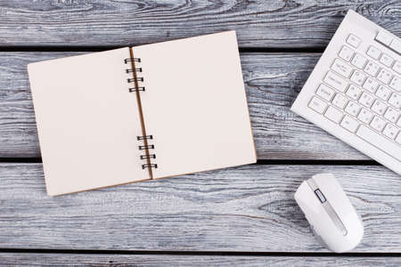 Notebook on wooden table. PC stuff. Minimalism concept.