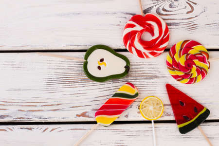 Composition with colorful lollipops. Mix of lollipops on wooden background with copy space. Tasty...